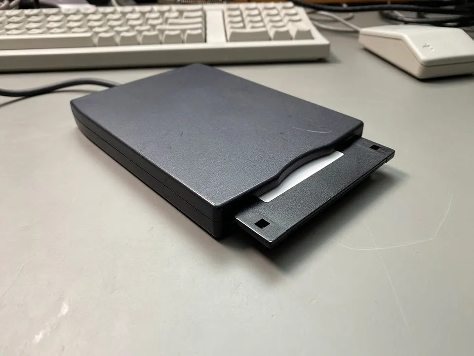 USB Floppy Drive sitting in front of a Macintosh